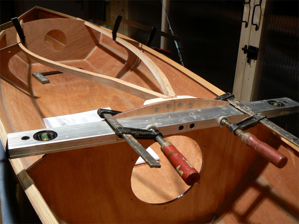 Cette vue montre bien le traitement subi par l'extr&eacute;mit&eacute; avant des &eacute;longis : j'ai coup&eacute; un scarf pour enlever la moiti&eacute; de la hauteur de chacune des lattes &agrave; l'extr&eacute;mit&eacute; avant, et j'ai recoll&eacute; la chute sur la face inf&eacute;rieure des &eacute;longis. Ainsi, l'extr&eacute;mit&eacute; avant des &eacute;longis est remont&eacute;e sans &ecirc;tre trop affaiblie, ce qui donne un meilleur "atterrissage" aux lattes du pontage, qui seraient sinon trop "tortur&eacute;es" par la courbure impos&eacute;e au passage de la cloison avant de venir se poser sur l'&eacute;longis. 