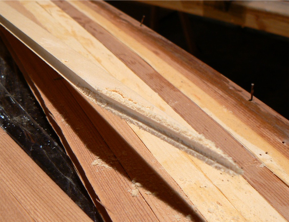 Je dois creuser le bout de la latte, car celui-ci doit devenir concave afin de "chevaucher" le bord convexe de la latte de fougère. Je commence à créer une gorge grâce à une lime de section triangulaire. 