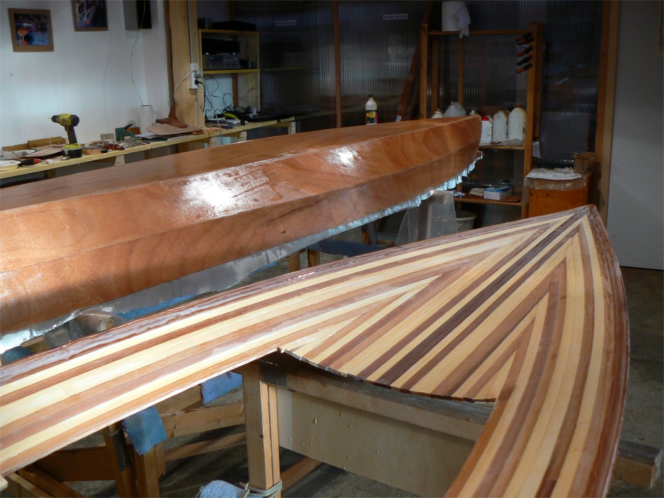 Ouf, ça y est, j'ai fini de saturer tout le tissu de verre, il ne restera plus qu'à couper ce qui dépasse quand l'époxy aura un peu durci. Le pont (à l'envers au premier plan) est prêt dès que la coque le sera : je ne stratifierai sa face inférieure que juste avant de le coller sur la coque afin d'éviter de le figer dans une forme qui ne soit pas parfaitement compatible avec la coque. 