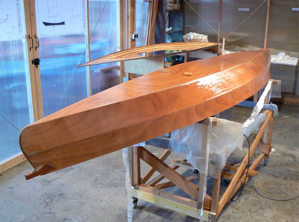 Le lendemain matin, j'ai coupé le tissu sous le livet et je me prépare à passer une seconde couche d'époxy pour remplir la trame du tissu. Les deux cales que l'on aperçoit sur la sole au niveau du tréteau arrière, au premier plan, servaient à soulever un peu la coque afin de permettre au tissu de "tomber" et de bien coller jusqu'en haut du carreau. 