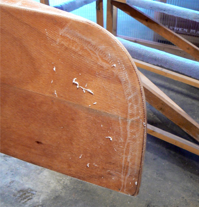 Avant de passer la seconde couche d'époxy, j'élimine au racloir les plus proéminentes des surépaisseurs (je serais un tueur au Scrabble) à l'étrave et à l'étambot. Voici l'étrave. 