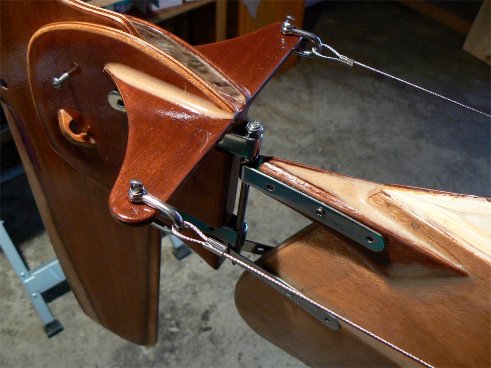 Retour au Mill Creek : nouvel essayage du gouvernail, j'ai connecté les câbles inox au palonnier. Le filoir sous la vis de pivotement du safran servira à fixer le tendeur qui le tiendra en position basse. Cette image montre qu'il faut que je repasse une couche d'époxy chargée à l'intérieur de la tête de gouvernail, car ce qu'on en voit manque de fini. 