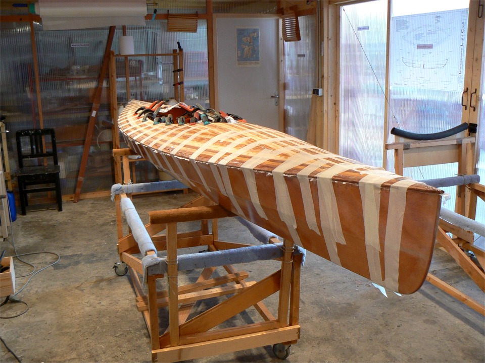 L'opération délicate a été de saisir le pont à l'envers, de le retourner (tout gluant de sa stratification toute fraîche), avec seulement deux mains, et de le poser du premier coup à sa place, sans pratiquement avoir à ajuster sa position après l'avoir posé... J'ai ensuite coupé le plus gros de l'excédent de tissu de verre qui dépassait du joint avant de coller la bande adhésive sur tout le pourtour et de poser les pinces sur l'élongis de cockpit. 