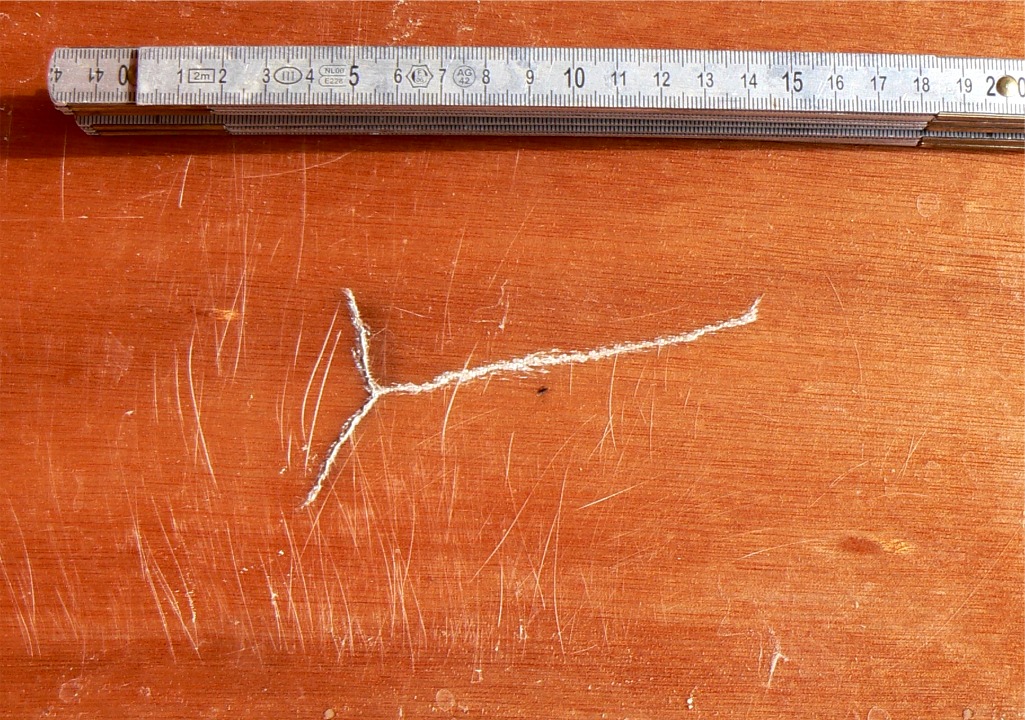 Voici le problème, tel qu'il est visible sur la face intérieure de la sole de "Piff", le Skerry de Jean-David. Je rappelle que celle-ci est en contreplaqué marine okoumé de 9 mm d'épaisseur, renforcé sur chaque face par une stratification époxy-verre avec un sergé 2/2 de 180 g/m2. La flexion imposée par l'impact extérieur a provoqué cette fente en patte d'oie limitée à la stratification et à la partie superficielle du contreplaqué. 