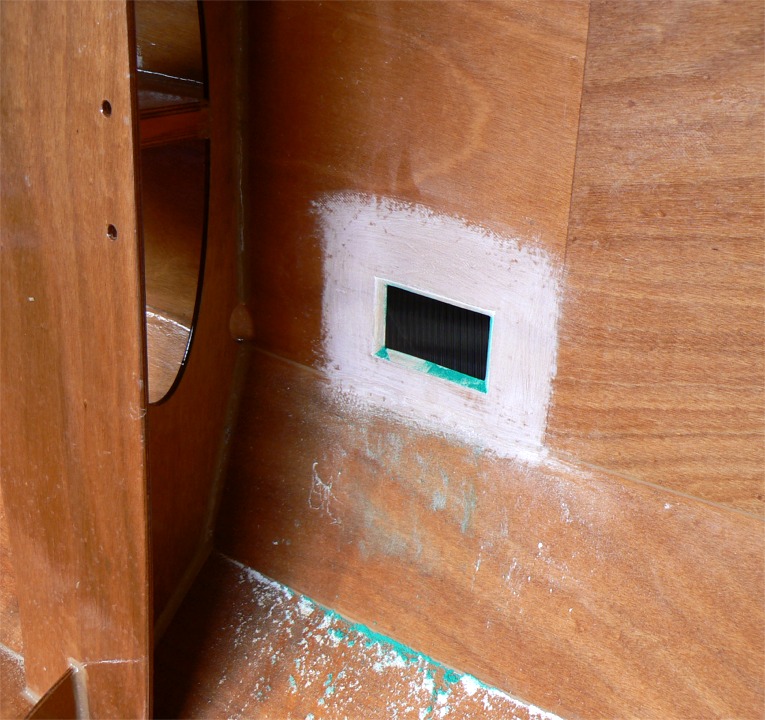 Après la découpe, je suis passé une seconde fois avec la scie sauteuse après avoir incliné sa lame à 45 degrés afin de créer un biseau (j'adore les petits biseaux !) pour faciliter le collage du placard et augmenter un peu la surface de contact. Le ponçage de la surface autour de la découpe donnera une bonne accroche à la reprise de stratification. Les traces vertes proviennent de la peinture de l'extérieur qui s'est invitée sous forme de poussière. L'aspirateur R2D2 nous en débarrassera dans quelques instants. 