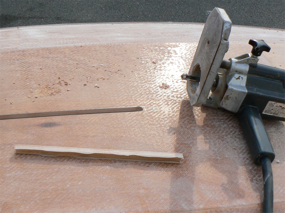 Après la scie, je sors la défonceuse (ah, ce nom !!!) équipée d'une fraise droite à guide (le petit roulement que l'on aperçoit en bas de la fraise), afin d'élargir l'ouverture du puits en l'alignant sur la face intérieure de ses flancs (relisez doucement, ça finit par être clair). 