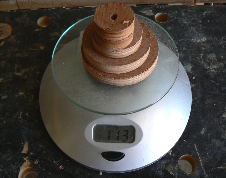 Par curiosité, j'ai pesé les chutes provenant des trous d'allègement et je n'arrive qu'à 113 grammes au total... Même en ajoutant le poids de la sciure, cela justifie diffcilement l'exercice, d'autant qu'au collage, les cavités vont se remplir partiellement d'époxy chargée qui aurait sinon été chassée des joints à la mise en pression, donc au final je ne dois même pas gagner 100 grammes sur une pièce qui pèse 2.4 kg. 