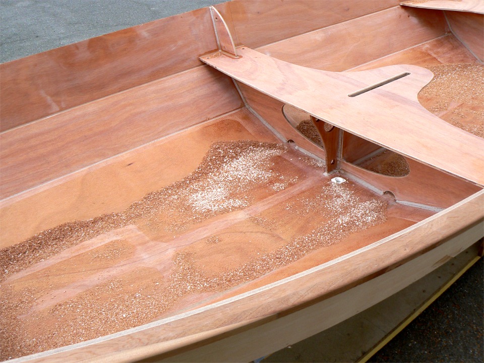 Le fond de Numéro 33 est couvert de copeaux et de sciure à l'issue de toutes ces opérations (notez que j'ai aussi passé la fraise en quart de rond sur l'arête extérierue des listons). Les copeaux clairs sont de l'époxy chargée, les autres sont essentiellement du sapelli des listons. Notez que j'ai posé un nable au pied de la membrure centrale. Le nable permet de vider rapidement le bateau quand il est sorti de l'eau (par exemple pour le rincer à l'eau douce. Il permet aussi de remplir rapidement le bateau, mais curieusement, cet usage est moins populaire. 