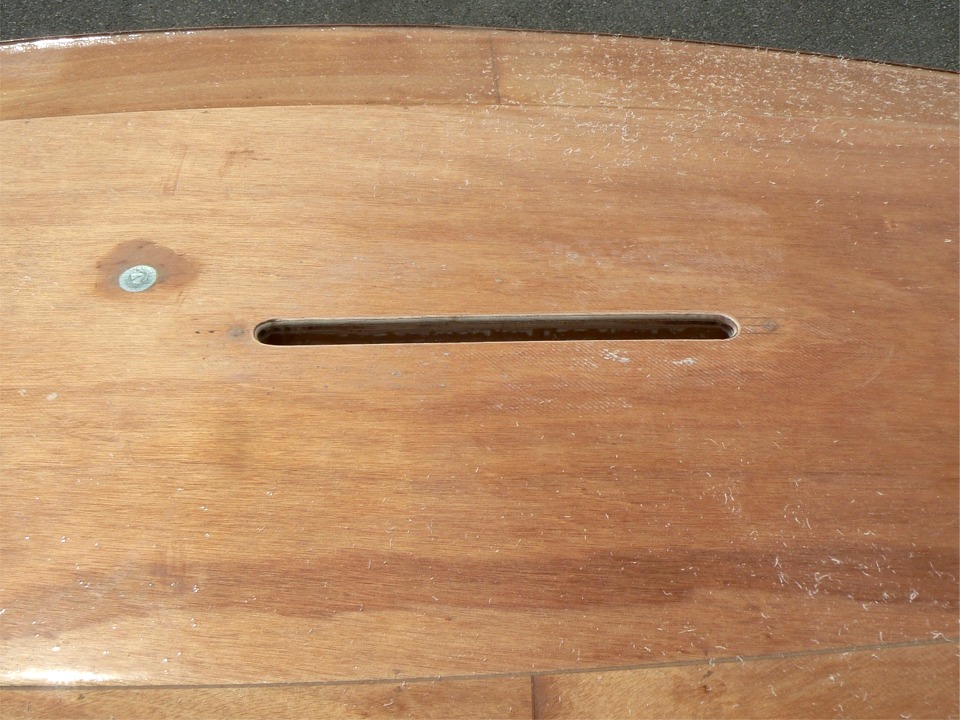 Et enfin, je passe la fraise en quart de rond pour "casser" l'angle droit sur la p&eacute;riph&eacute;rie de l'ouverture du puits de d&eacute;rive. La pastille argent&eacute;e que l'on aper&ccedil;oit &agrave; gauche est une rustine de bande adh&eacute;sive plastifi&eacute;e que j'ai coll&eacute;e sur le nable pour &eacute;viter que la stratification du fond de la coque, faite apr&egrave;s sa pose, le bloque d&eacute;finitivement.