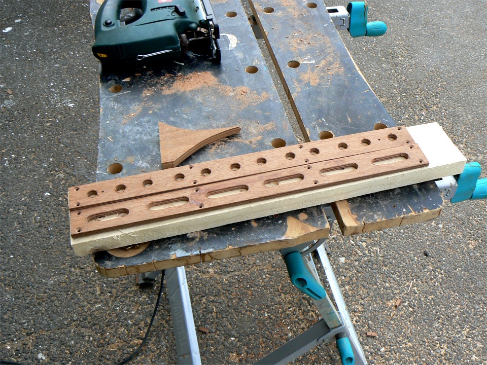 Je d&eacute;coupe les r&eacute;glettes de r&eacute;glage du cale-pied d'aviron. Je commence par percer les trous en 12 mm, puis je relie les trous &agrave; la scie sauteuse. Je n'ai pas de fraise droite assez fine pour r&eacute;aliser cette op&eacute;ration &agrave; la d&eacute;fonceuse, pour laquelle il me faudrait de toute fa&ccedil;on d&eacute;couper d'abord un gabarit. 