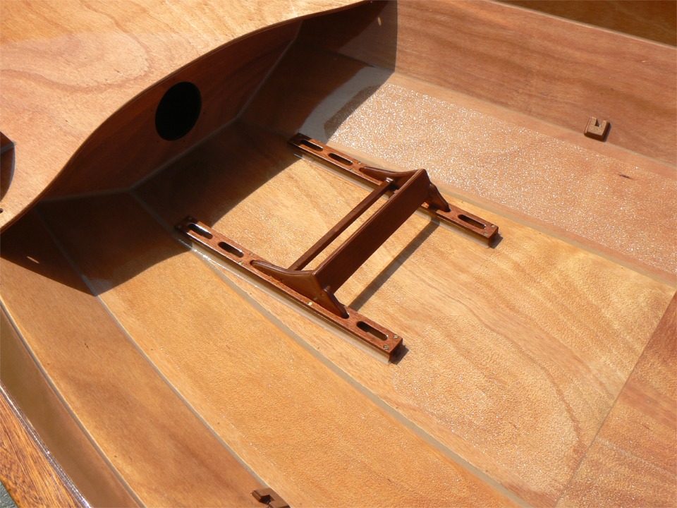 La semaine derni&egrave;re, j'avais fini la peinture du Skerry du Chasse-Mar&eacute;e, et j'avais encha&icirc;n&eacute; avec le vernis de "Num&eacute;ro 33" (le Skerry que je me d&eacute;p&egrave;che de construire pour participer &agrave; la Semaine du Golfe, et qui est le 33e bateau que je construis). Voil&agrave; ce vernis, et j'ai pos&eacute; le cale-pied d'aviron sur ses r&eacute;glettes de calage, pour montrer comment &ccedil;a marche. On peut donc le r&eacute;gler sur quatre posiitons : sur l'image il est sur la seconde position : moyen-court (pour les jambes !) 