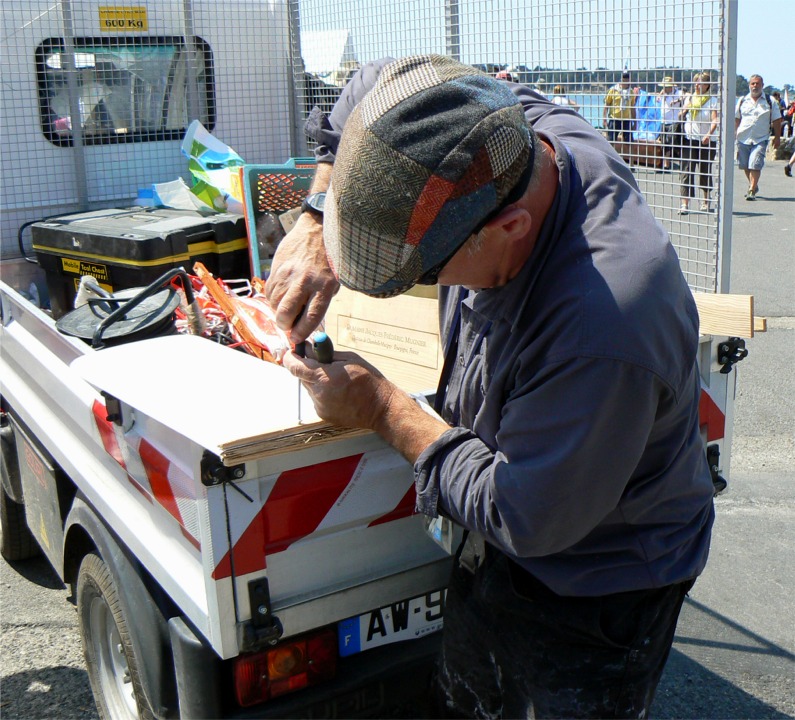 C'est ce qui s'appelle "au cul du camion" (ah bon, c'est autre chose ?) Gérard visse des bouts de bois sur le moignon de dérive qui lui reste après qu'un remorquage trop musclé l'ait brisée au ras de la sortie du puits, au hasard d'une embardée. Gérard avait été embarqué par le courant au passage de la Jument, qu'il n'avait pas pu serrer à cause du trop grand nombre de bateaux.