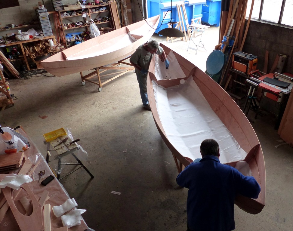 D&egrave;s que l'&eacute;poxy des joints n'est plus collante, nous drapons le tissu de verre de stratification, que nous allons lier &agrave; la surface du contreplaqu&eacute; en le saturant d'&eacute;poxy. Nous utilisons une grance pi&egrave;ce de tissu pour le compartiment central et deux petites pour l'int&eacute;rieur des futurs caissons &eacute;tanches. Seule la surface de la sole et des deux bord&eacute;s 1 est couverte. Deux bandes seront ensuites ajout&eacute;es pour renforcer l'&eacute;trave et l'&eacute;tambot. 