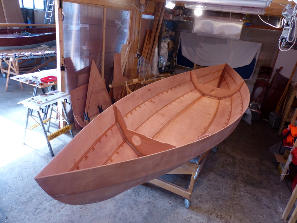 Voici le volet 1 de cette suite : apr&egrave;s avoir aussi d&eacute;pos&eacute; la cloison centrale, je viens de faire tous les joints int&eacute;rieurs et de boucher l'extr&eacute;mit&eacute; int&eacute;rieure de tous les trous de sutures. L'&eacute;poxy "fra&icirc;che" est clairement visible en "mouill&eacute;" sur le fond terne de la couche d'impr&eacute;gnation ponc&eacute;e. 