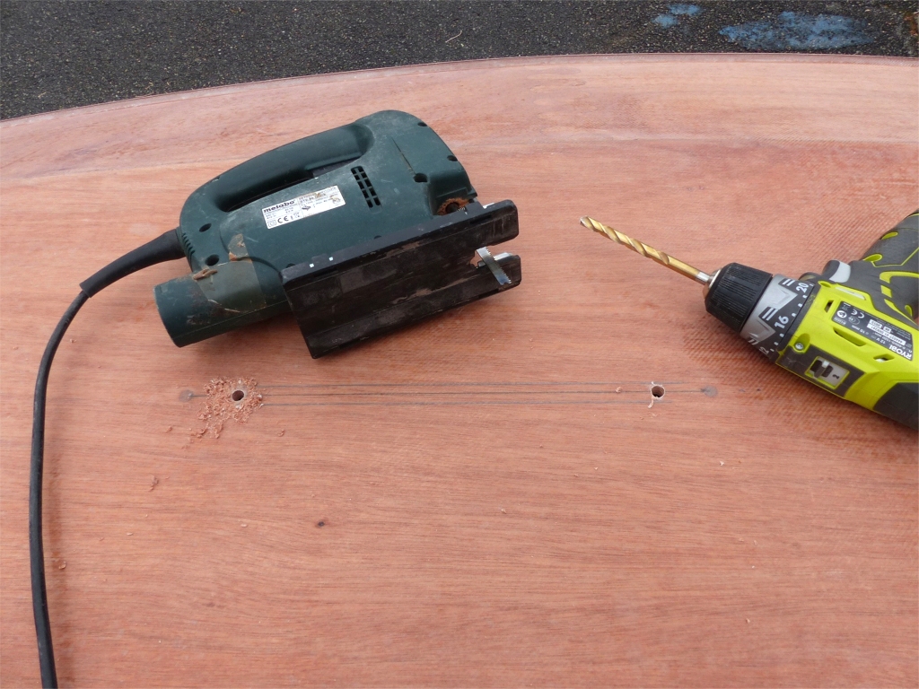 Apr&egrave;s un bon d&eacute;poussi&eacute;rage &agrave; l'aspirateur puis au chiffon mouill&eacute;, j'attaque l'ouverture du puits de d&eacute;rive, que je r&eacute;sume en 4 images. Je commence ici par deux trous de 8 mm sur une droite trac&eacute;e entre les deux vis de fixation du puits de d&eacute;rive &agrave; travers la sole qui vont me permettre d'introduire la lame de la scie sauteuse. Notez que j'ai aussi trac&eacute; deux droites &agrave; 7mm de part et d'autre de l'axe, le long desquelles je vais maintenant faire mes deux traits de scie sauteuse. 