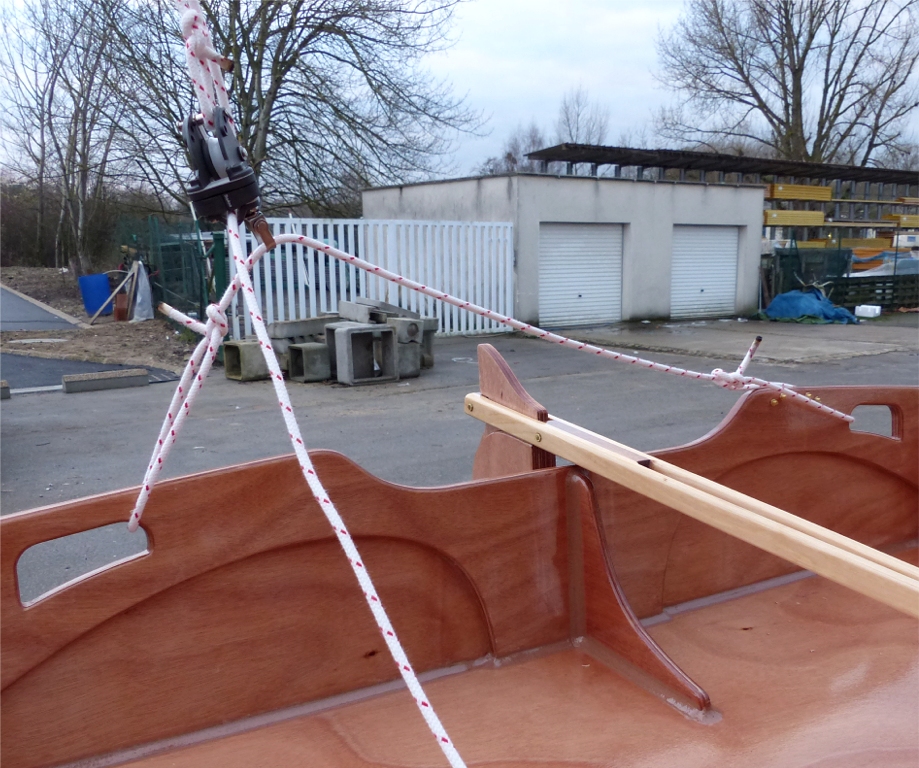 Du c&ocirc;t&eacute; de l'&eacute;coute, la poulie basse du palan circule librement sur une patte d'oie nou&eacute;e entre les deux poign&eacute;es du tableau arri&egrave;re : on r&egrave;gle sa longueur et l'emplacement des noeuds pour d&eacute;terminer le d&eacute;battement lat&eacute;ral de la poulie sur cette barre d'&eacute;coute textile. 