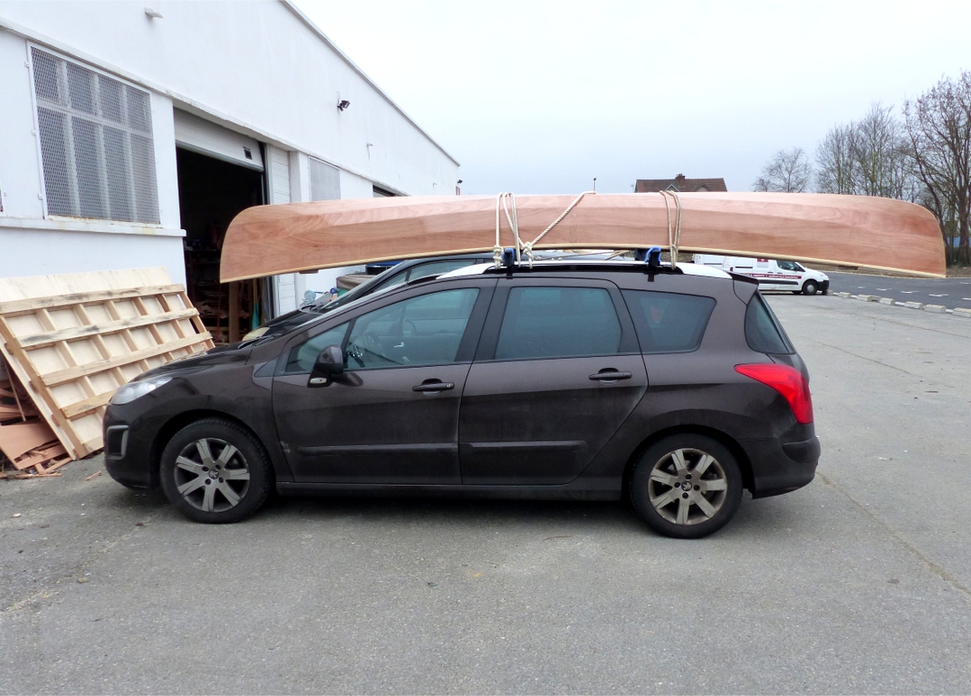 Voici les restes de la palette de 3.10 m par 1.53 m devant la voiture d'Alain sur laquelle nous avons charg&eacute; le Cavelier. Comme vous le voyez, il est centr&eacute; sur les barres de toit et d&eacute;passe largement en arri&egrave;re, ce qui est autoris&eacute; &agrave; concurrence de 3 m&egrave;tres. En effet, le chargement d'un v&eacute;hicule ne doit en aucun cas d&eacute;passer &agrave; l'avant. Par contre, il peut d&eacute;passer &agrave; l'arri&egrave;re du v&eacute;hicule dans la limite de 3 m, &agrave; condition d'&ecirc;tre signal&eacute; par un dispositif r&eacute;fl&eacute;chissant, compl&eacute;t&eacute; de nuit par une lumi&egrave;re rouge, selon l'article R312-21 du Code de la Route. Voyez &eacute;galement les deux excellents articles de mars 2013 sur le site de la FFCK. 