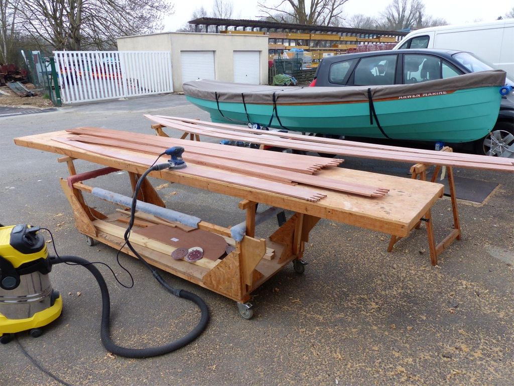 Ce samedi, le Silmaril est de retour &agrave; l'atelier pour assister &agrave; une s&eacute;ance de pon&ccedil;age : ce sont les virures 4, 5 et 6 qui sont sur les tr&eacute;teaux, pr&ecirc;tes &agrave; poser, je viens de poncer le collage de leur joint-puzzle, et sur la table au premier plan j'&eacute;grenne la surface des demi-virures 7, 8 et 9 suite &agrave; l'impr&eacute;gnation &eacute;poxy. Je dois ensuite coller leurs propres joints-puzzle, puis poncer ce collage, avant de pouvoir les poser. Il ne me restera plus que les virures 10, qui font office de pavois et seront pos&eacute;es apr&egrave;s le pont. 