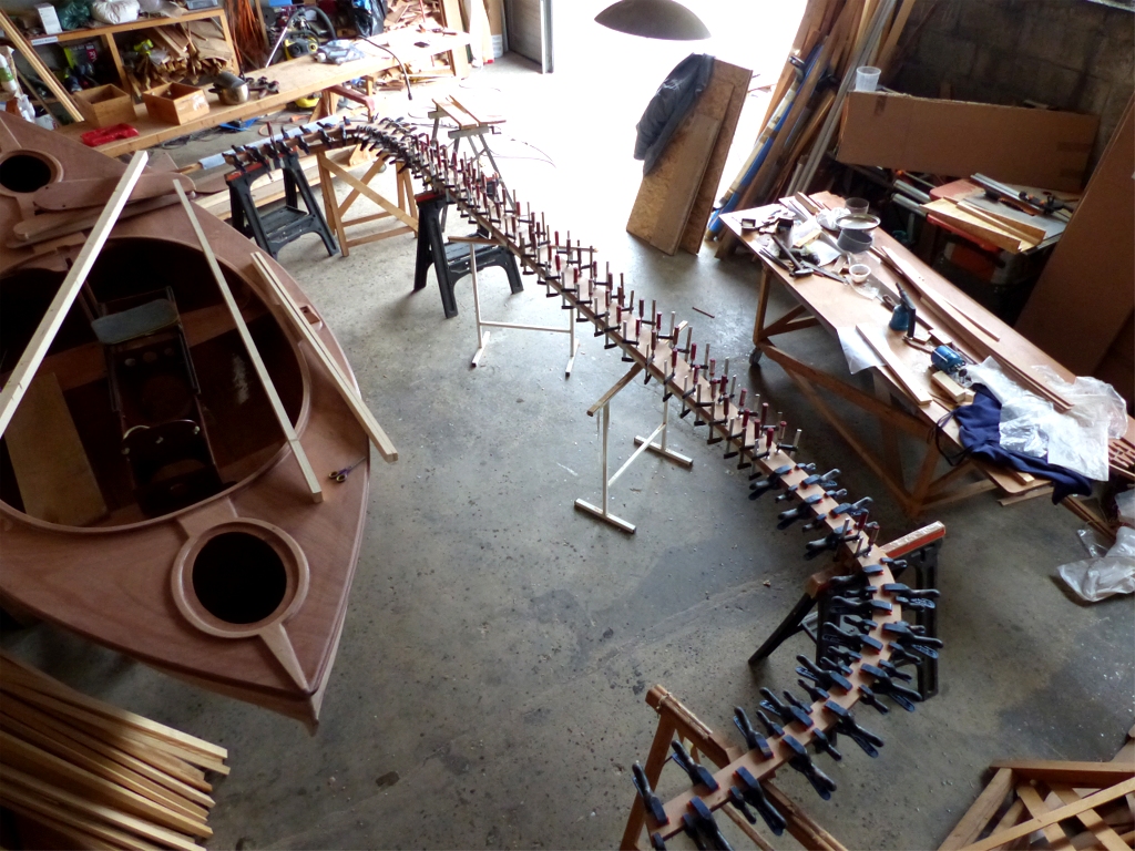 Je termine par une vue a&eacute;rienne de ce collage. Le Skerry Raid a &eacute;t&eacute; d&eacute;log&eacute; de la partie chauffable de l'atelier sous la mezzanine par la barquette. On aper&ccedil;oit dans son cockpit le support mobile de coulisse que j'ai construit l'ann&eacute;e derni&egrave;re pour la Yole de Chester : je vais l'utiliser comme mod&egrave;le pour en faire un nouveau adapt&eacute; au Skerry Raid. En effet, j'ai pr&eacute;vu (si ma candidature est accept&eacute;e) de participer au Challenge Naviguer L&eacute;ger organis&eacute; dans les Pertuis par le Chasse-Mar&eacute;e fin juin, et une partie du parcours devra &ecirc;tre effectu&eacute;e &agrave; l'aviron. 
