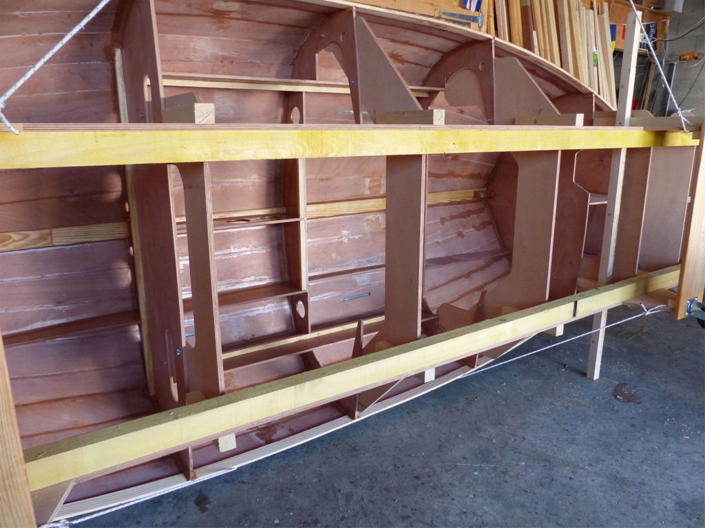 Sur la barquette, que voici pos&eacute;e &agrave; 90&deg;, j'ai "nettoy&eacute;" et refait tous les joints int&eacute;rieurs entre les virures, et fait des joints cong&eacute;s &agrave; tous les points de contact de la structure et du bordage. 