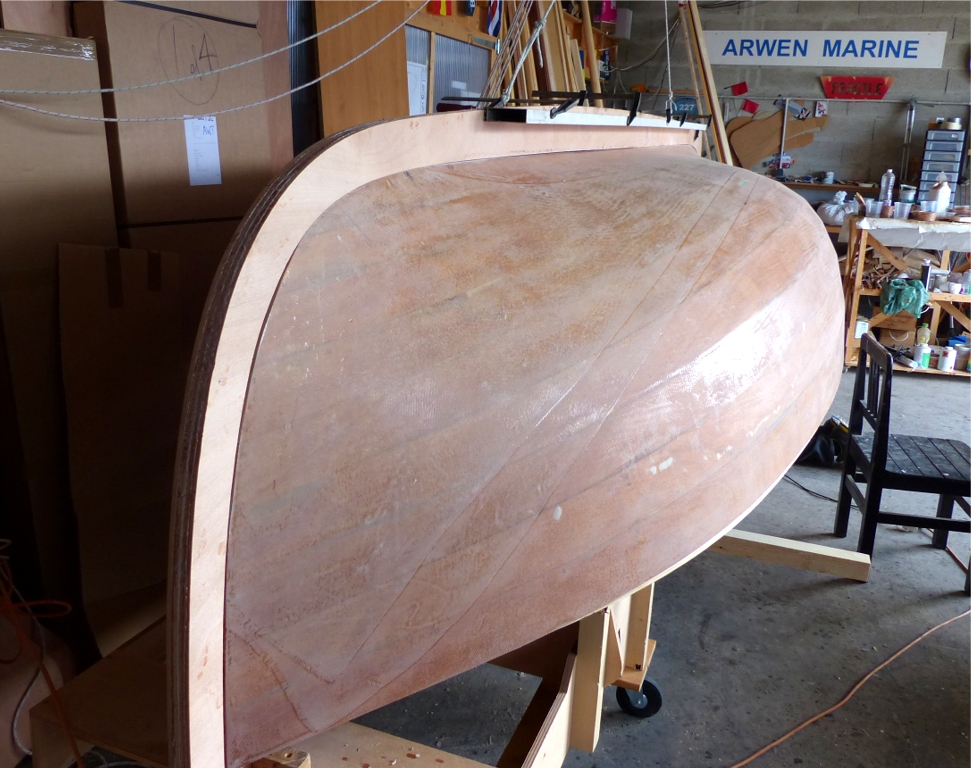 Et &ccedil;a y est ! L'ensemble fausse &eacute;trave-fausse quille-faux &eacute;tambot est boulonn&eacute;-coll&eacute; sur la barquette, plus qu'&agrave; faire les joints de la r&acirc;blure. La r&ecirc;gle en alu assure que la partie la plus longue de la fausse quille reste rectiligne pendant le collage. Nous avons utilis&eacute; un de mes deux palans avec une patte d'oie pour lever et pr&eacute;senter l'ensemble sur la coque retourn&eacute;e, apr&egrave;s avoir perc&eacute; pour les tire-fonds de fixation et grassement encoll&eacute; la surface de contact &agrave; l'&eacute;poxy charg&eacute;e.