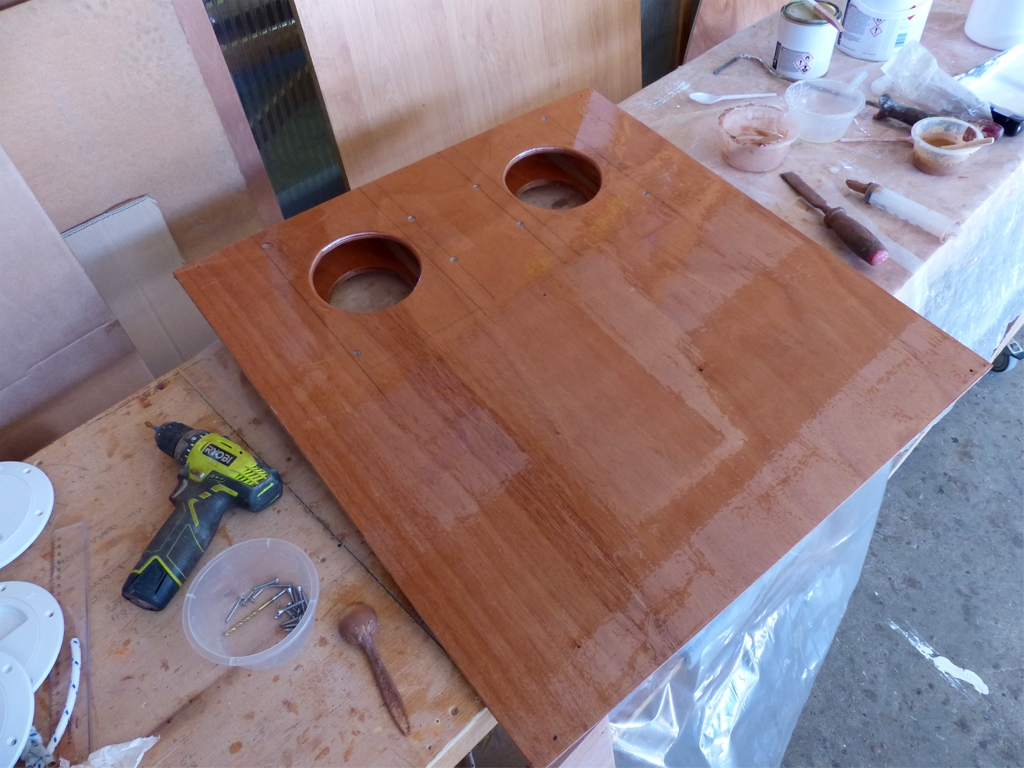 Apr&egrave;s avoir viss&eacute; les 8 vis qui fixent l'ensemble du pied de m&acirc;t et des trappes sur le couvercle du ballast, je retourne celui-ci et passe une derni&egrave;re couche d'&eacute;poxy claire avant de le coller &agrave; son tour. J'avais auparavant d&eacute;coup&eacute; deux ouvertures rondes sous les trappes, bien s&ucirc;r ! 