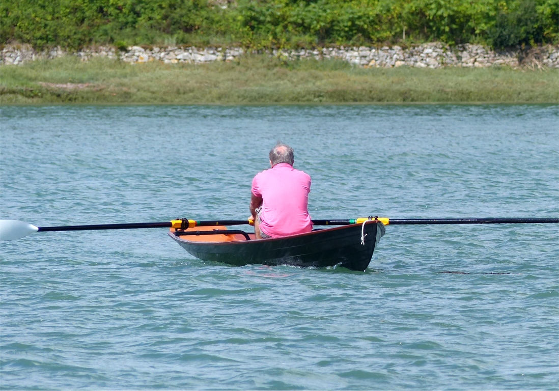 Cette vue de 3/4 avant montre comme les deux virures hautes sont évasées afin de réduire la largeur à la flottaison tout en ménageant une réserve de flottabilité latérale si le Wherry prend de la gîte ou doit franchir un sillage. En effet le sillage de bateau à moteur est l'Ennemi (E majuscule) du Wherry et de tous les petits bateaux à franc-bord faible ou modéré, car les vagues générées sont abruptes et très proches, et le petit bateau ne peut pas "monter à la lame" : il passe à travers s'il a le temps de faire face, ou il se fait rouler. Dans les deux cas, il risque de se remplir et de chavirer... 