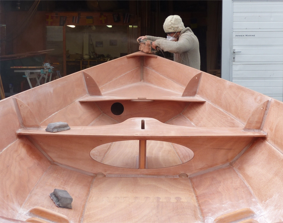 Le pon&ccedil;age rituel de ce matin est tr&egrave;s salissant, car nous utilisons cette fois-ci la ponceuse &agrave; bande pour araser le dessus des listons, dont le collage a durci pendant la nuit. Les cales &agrave; poncer t&eacute;moignent de quelques autres petits pon&ccedil;ages de d&eacute;tail, notamment sur les joints-cong&eacute;s des cale-pieds. 