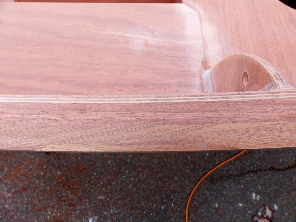 Cette seconde image montre le liston tribord juste en arri&egrave;re de la cloison centrale. On distingue ais&eacute;ment le scarf de la latte ext&eacute;rieure car le fil du bois est en chevrons. Il reste un tout petit peu d'&eacute;poxy charg&eacute;e &agrave; la pointe ext&eacute;rieure du scarf, mais elle sera &eacute;limin&eacute;e quand je vais passer un coup de fraise en quart de rond pour arrondir l'ar&ecirc;te ext&eacute;rieure. 