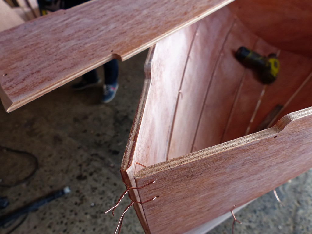 Petit retour en arrière avant la mise en place de la dernière paire de virures. Notez que nous avons doublé la suture du haut de la paire de virures N°5, mais nous ne les avons pas très serrées car nous ne recherchons pas à obtenir une étrave bien pointue à ce stade. On ajustera la tension quand la dernière paire de virures sera en place. Notez aussi le chanfrein que nous avons fait à mi-bois afin de créer une surface de contact à la place des deux arêtes, et, dernier point, comment nous avons arrondi l'angle du décrochement de l'étrave; là où la feuillure d'interrompt (cf image 40 ci-dessus). 