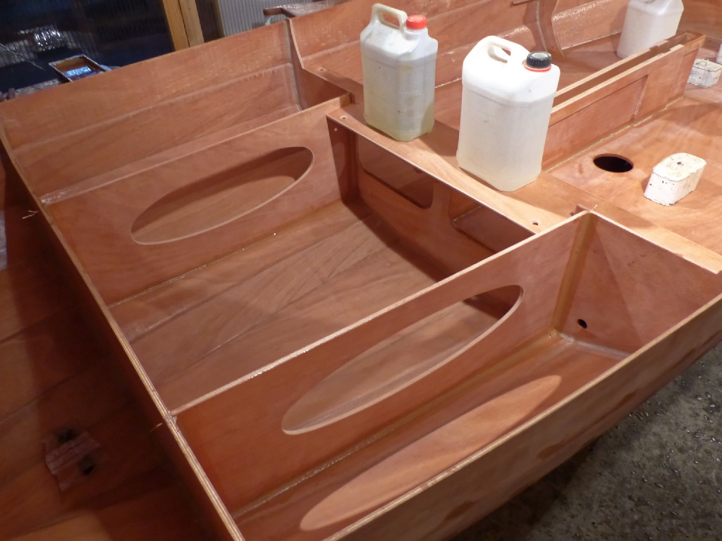 Collage du banc transversal arrière. Benoit a choisi de faire cette découpe ovale dans les bat-flancs sous le siège du barreur en "U" afin d'en faire des équipets ouverts. Ils sont livrés sans ouverture et peuvent être munis d'une trappe ronde pour en faire des compartiments étanches de stockage. JE pense que la solution choisi par Benoit est bonne car on a bien assez de volume de flottabilité et de rangement étanche.