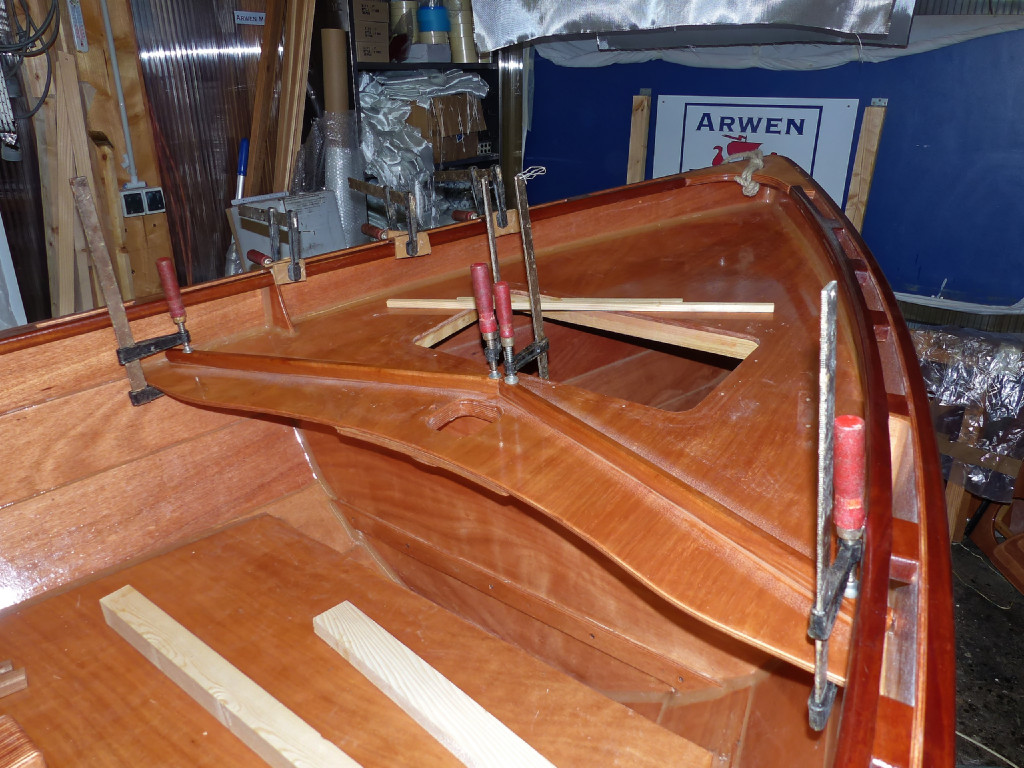 Après durcissement et ponçage, nous remettons le bateau à l'endroit pour coller ce pretit brise-lames, dont le rôle est d'envoyer les embruns tombant sur le pont avant vers une petite évacuationsur chaque bord. 