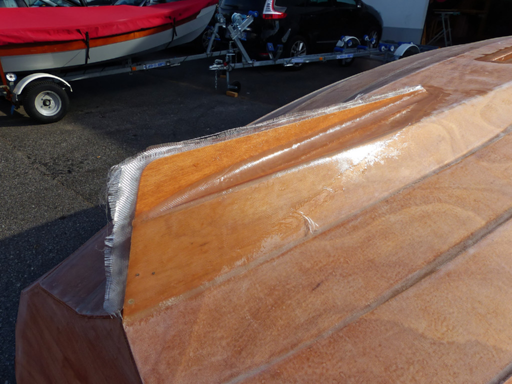 Le collage de l'aileron est renforcé par de gros joints-congés latéraux, eux-même couverts par une pièce de tissu de verre qui couvre totalement l'aileron et remonte sur l'arrière de la première virure afin de diffuser les efforts subis par l'aileron. 