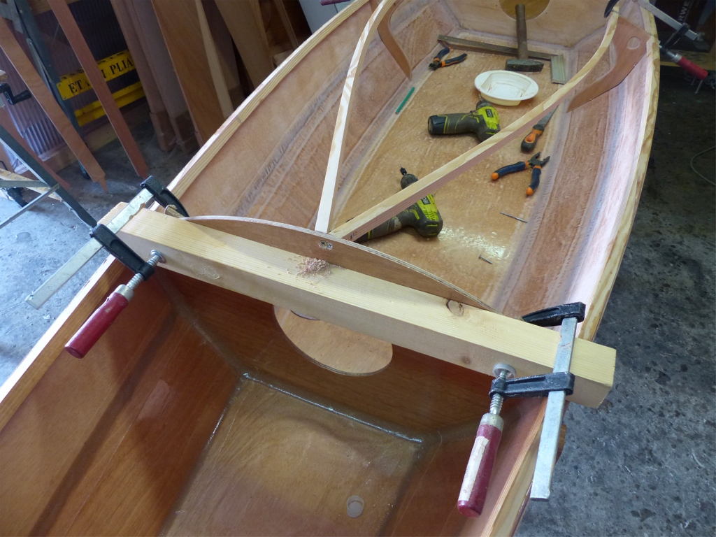 Retour sur le Mill Crrek 13 : J'ai sutur&eacute; en place les deux courbes verticales qui soutiennent l'&eacute;longis qui borde l'ouverture du cockpit et supportera les deux grands c&ocirc;t&eacute;s de l'hiloire, puis j'ai cintr&eacute; en place les deux &eacute;longis. Ils exercent une pression assez forte sur le haut de la cloison avant, et j'ai donc pos&eacute; un bout de tasseau tenu par deux presses afin de raidir celle-ci jusqu'au collage. 