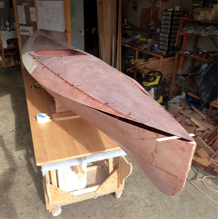 Apr&egrave;s avoir ponc&eacute; tout le bord de la surface int&eacute;rieure du pont et de la coque sur 5 cm de large afin de donner une accroche au futur joint-cong&eacute; du livet, je me suis attel&eacute; &agrave; une t&acirc;che que je redoute un peu : le collage &agrave; la bande adh&eacute;sive du pont sur la coque. Bien s&ucirc;r, la bande adh&eacute;sive sera enlev&eacute;e quand le joint &eacute;poxy sera fait. On voit ici que j'ai commenc&eacute; &agrave; l'arri&egrave;re et que je progresse vers l'avant, 10 cm &agrave; la fois en alternant les c&ocirc;t&eacute;s. Le manuel de construction pr&eacute;conise de faire cette op&eacute;ration pendant que les joints du pont sont encore "frais" afin que celui-ci se conforme au contour de la coque au livet. On doit ensuite d&eacute;solidariser le pont de la coque pour mettre les bandes de fibre de verre de renfort avant de faire l'assemblage d&eacute;finitif. Je viens de prouver que cette &eacute;tape interm&eacute;diaire n'est pas n&eacute;cessaire. 