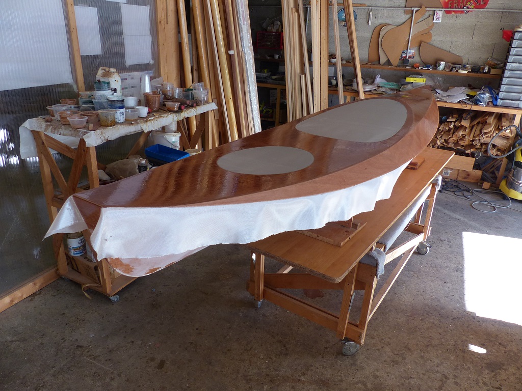 Je commence par saturer le tissu de verre sur le pont, et je m'appr&ecirc;te &agrave; saturer &eacute;galement le tissu que j'ai laiss&eacute; d&eacute;passer sur le haut de la coque afin de le plaquer sur celle-ci. Je ferai ult&eacute;rieurement la stratification de la coque, qui viendra couvrir le "retour" du tissu du pont. 