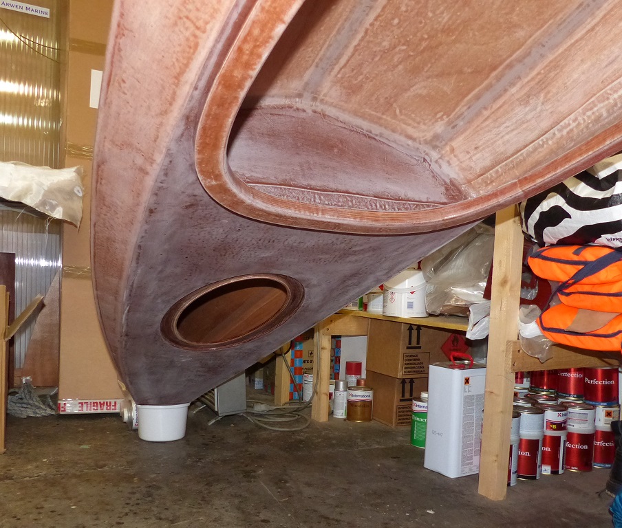 Comme pour l'avant, j'ai retourn&eacute; et inclin&eacute; le kayak en trempant l'extr&eacute;mit&eacute; dans un petit seau d'eau. Il a fallu que j'aille ramper sous le bateau jusqu'&agrave; l'ouverture de la trappe et que j'y passe le bras pour verser le verre d'&eacute;poxy additionn&eacute;e de micro sph&egrave;res &agrave; l'aveugle. Ce n'est qu'apr&egrave;s que j'ai pu passer la t&ecirc;te et la frontale pour v&eacute;rifier mon travail, car l'ouverture de la trappe est trop petite pour y passer la t&ecirc;te et le bras, a fortiori maintenant que le seuill de trappe est en place. 