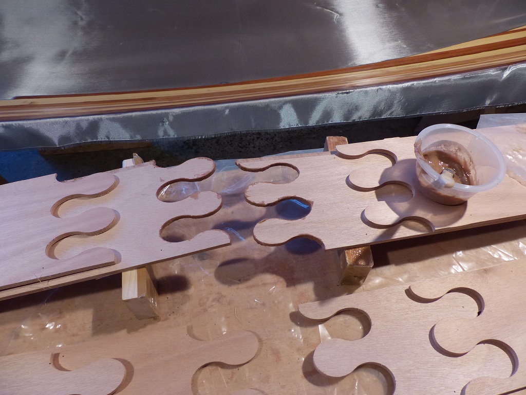 Collage des joints-puzzle des bord&eacute;s de la Yole de Chester : je colle les paires de bord&eacute;s b&acirc;bord-tribord l'un sur l'autre afin de gagner de la place et d'assurer leur conformit&eacute; pr&eacute;cise en v&eacute;rifiant qu'ils sont parfaitement superpos&eacute;s. J'enduis d'&eacute;poxy charg&eacute;e le chant de la d&eacute;coupe sur chacune des moiti&eacute;s. 