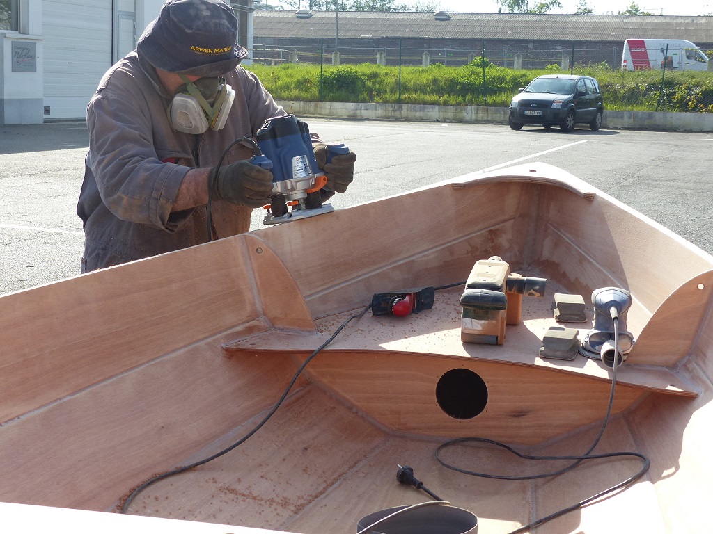 Le lendemain, l'&eacute;poxy du collage des listons ayant durci, nous enlevons toutes les presses et pinces et "finissons" les listons. Nous avons commenc&eacute; &agrave; la ponceuse &agrave; bande pour araser les deux lattes et le haut du carreau, puis Pierre utilise la d&eacute;fonceuse afin de cr&eacute;er un quart de rond sur l'ar&ecirc;te haute de l'ext&eacute;rieur des listons. 