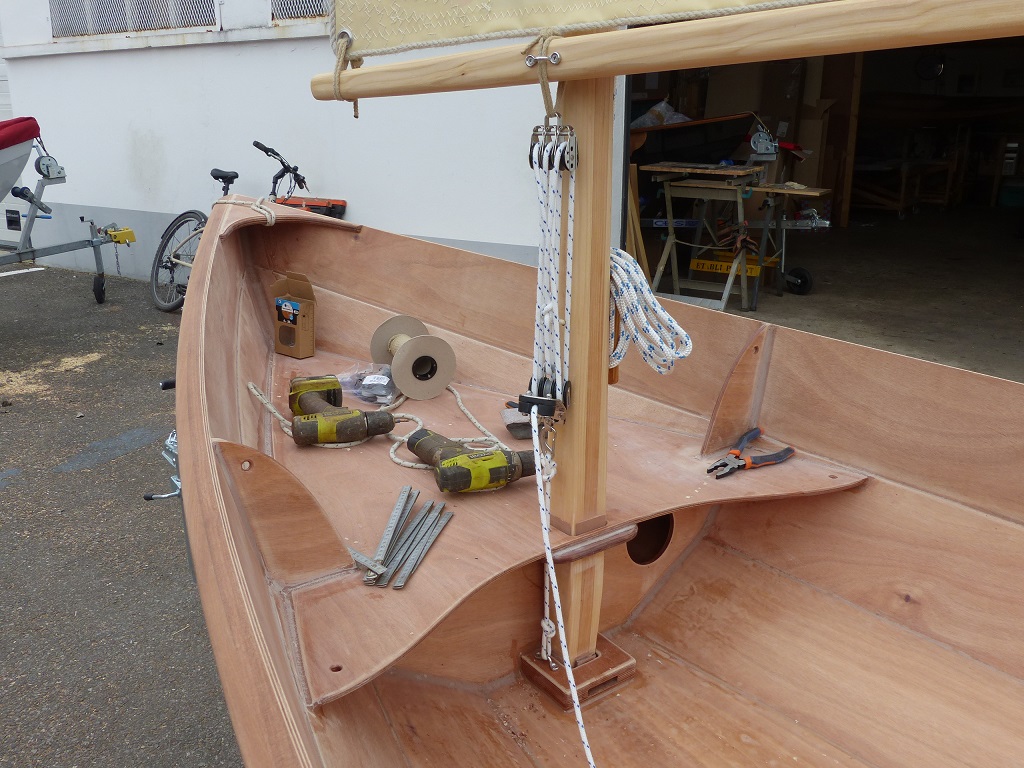 Gros plan sur le palan d'amure et sa fixation renvoy&eacute;e sur le pied de m&acirc;t. Ce palan &agrave; six brins permet d'&eacute;tarquer vigoureusement la voile au tiers b&ocirc;m&eacute;e afin d'en obtenir le rendement optimal. Sa puissance permet de le r&eacute;gler sans effort, et donc fr&eacute;quemment, en fonction de l'allure. 