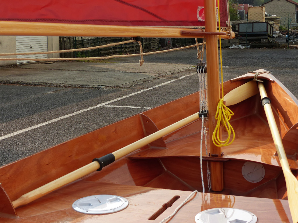 On envoie la voile en tête de mât et on attache la drisse. Le réglage de la tension sur l'amure se fait grâce au palan à 6 brins dont le courant est assez long pour revenir à la main du barreur, qui peut ainsi le régler sans effort afin d'adapter le réglage instantanément. 