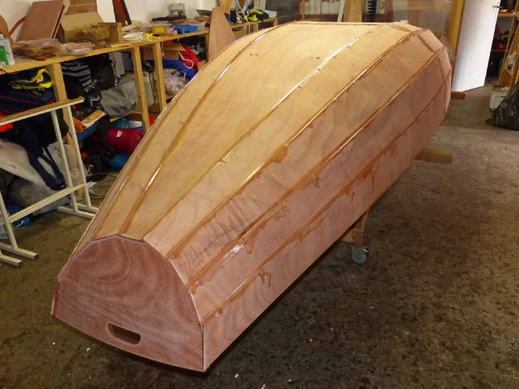 Je reviens au PassageMaker Dinghy pour faire le premier collage par l'ext&eacute;rieur apr&egrave;s avoir sollicit&eacute; (et obtenu) l'aide de la bonne samaritaine pour retourner la coque, puis resserr&eacute; une &agrave; une chacune des sutures apr&egrave;s retournement. En effet, le retournement "tasse" les panneaux et on peut reprendre un peu de mou sur les sutures. La colle (&eacute;poxy charg&eacute;e) est ensuite appliqu&eacute;e &agrave; la seringue dans les joints, puis liss&eacute;e &agrave; la cuiller. 