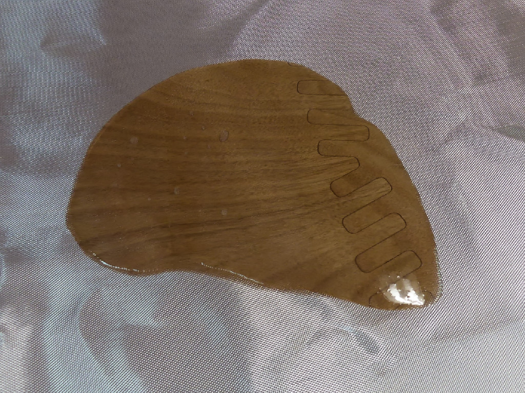 Je viens de verser un peu d'&eacute;poxy sur le tissu de verre, au niveau du joint-puzzle de la sole : la r&eacute;sine mouille le tissu et le rend transparent, sauf aux endroits o&ugrave; quelques petites bulles d'air subsistent. 