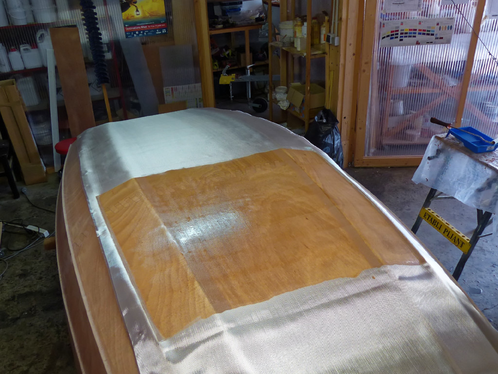 Et je commence &agrave; saturer le tissu de verre de r&eacute;sine &eacute;poxy au rouleau. 