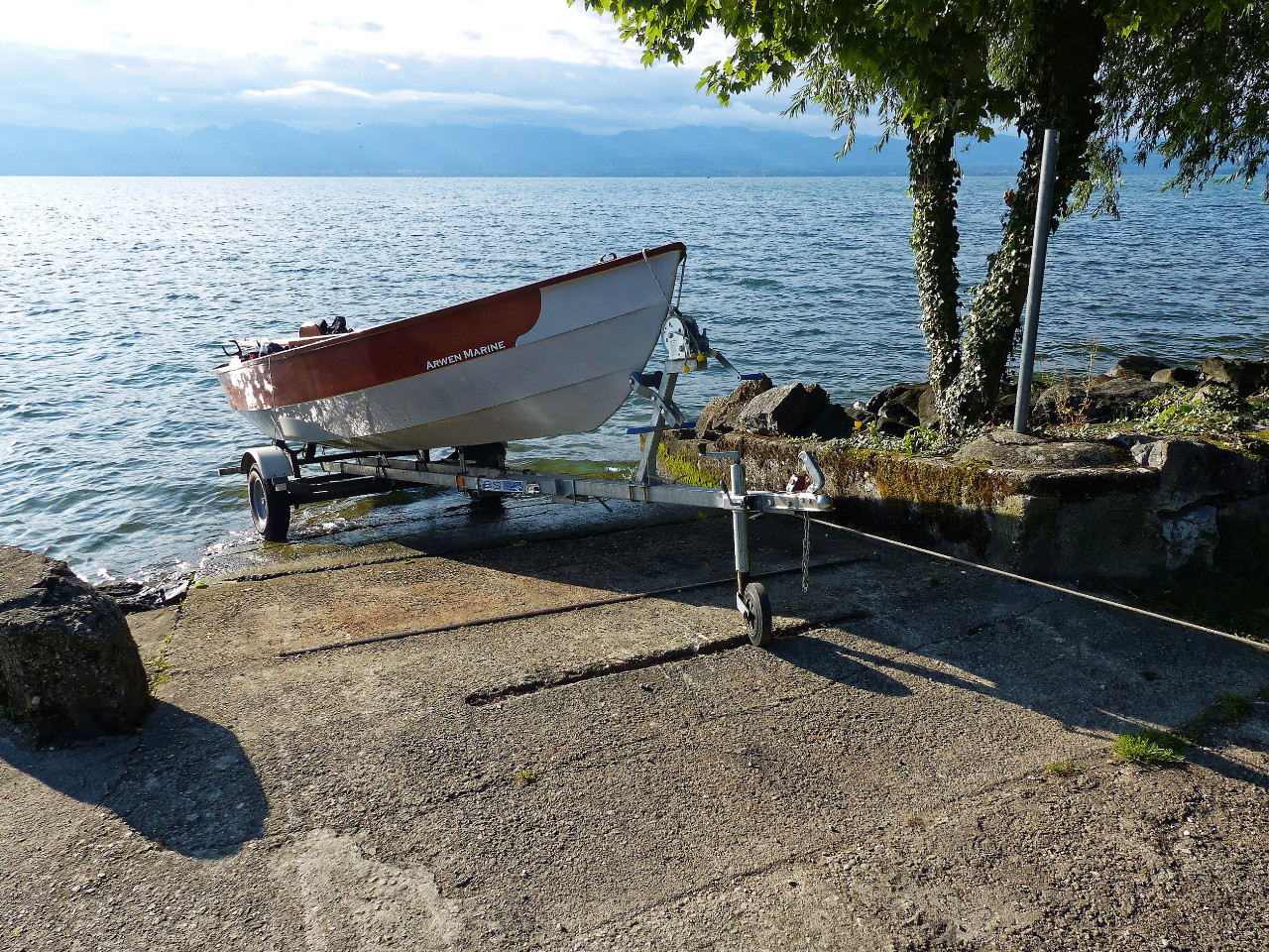 Je suis arrivé à Rolle vendredi soir par le poste frontière de Cure, en passant par Les Rousses. Cette route est la plus directe et elle évite de prendre quelques km d'autoroute qui nécessiteraient d'acheter une vignette pour la voiture et une autre pour la remorque (40.00CHF par vignette). Claude m'a gentiment piloté sur les derniers km depuis Les Rousses et nous avons retrouvé au camping Marco, venu avec "Eolo", Hervé venu avec "Enfin!" et Martial avec "Aldies II". Samedi matin, nous avons mis les bateaux à l'eau sur la rampe du tout petit port voisin du camping en amenant les remorques à la main par le sentier du bord de lac. J'ai attaché celle de "Gandalf" à un arbre afin de l'immobiliser tandis que je poussais "Gandalf" à l'eau. 