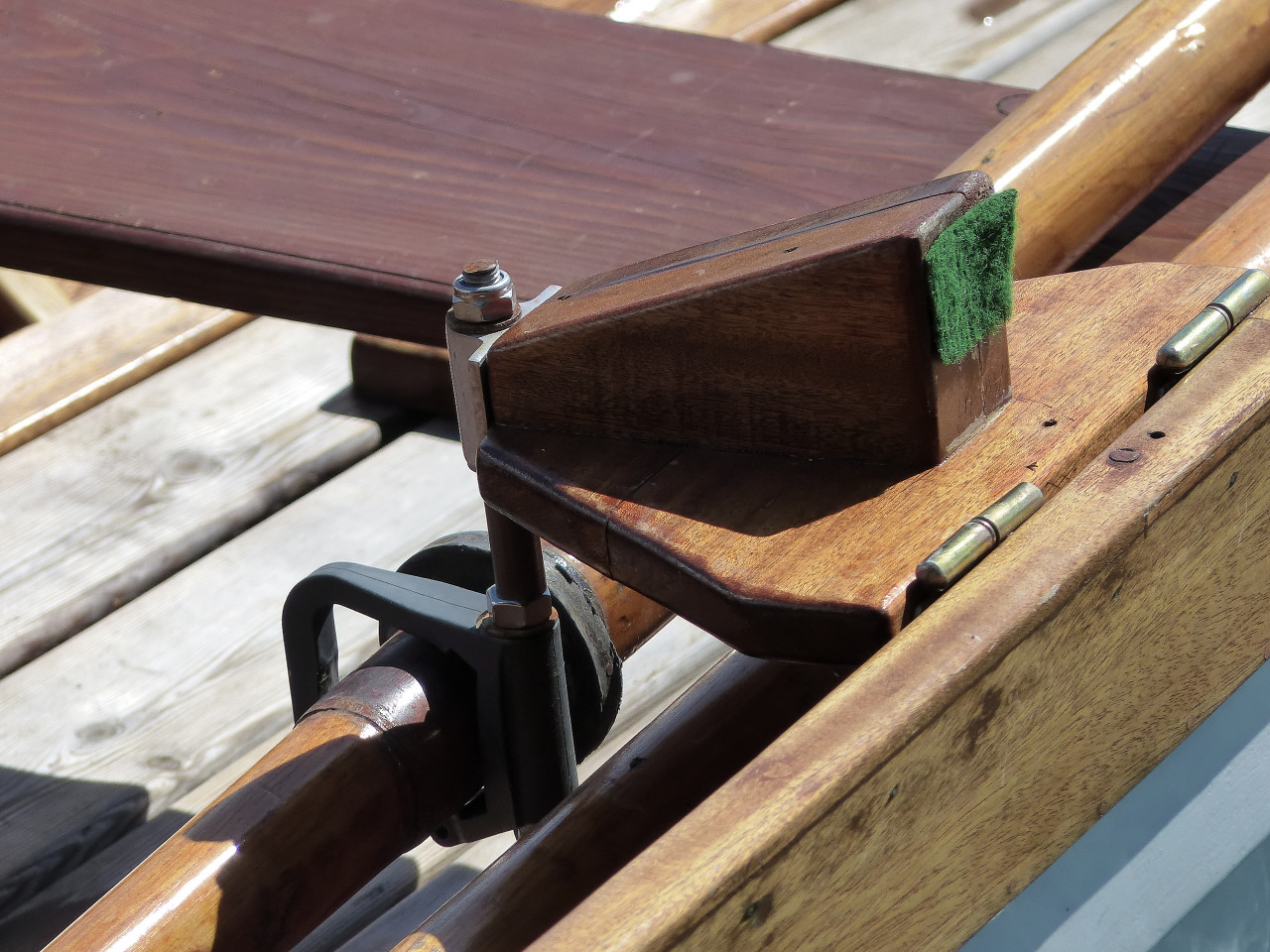 Gros plan sur l'outrigger tribord avant, en position repliée. Lorsqu'il est déplié, le morceau de feutre vert vient reposer sur l'extérieur du carreau. 