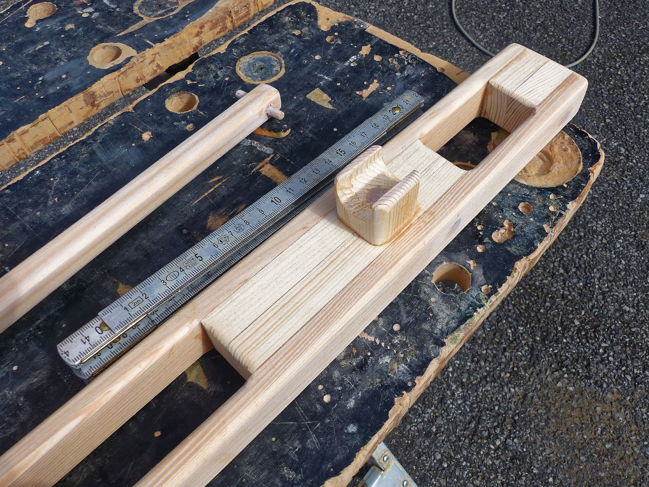 Apr&egrave;s un petit pon&ccedil;age, le repose-stick est perc&eacute;-frais&eacute; et il sera tenu par une vis au fond du "U", en plus du collage &agrave; l'&eacute;poxy. Notez le petit bout de tourillon de 6mm qui traverse l'extr&eacute;mit&eacute; du stick : le stick d'une de mes premi&egrave;res barres m'a &eacute;chapp&eacute; des doigts &agrave; un mauvais moment, d&eacute;sormais cela n'arrive plus ! J'ai ajout&eacute; le m&egrave;tre sur cette image afin de donner une id&eacute;e de l'&eacute;chelle.