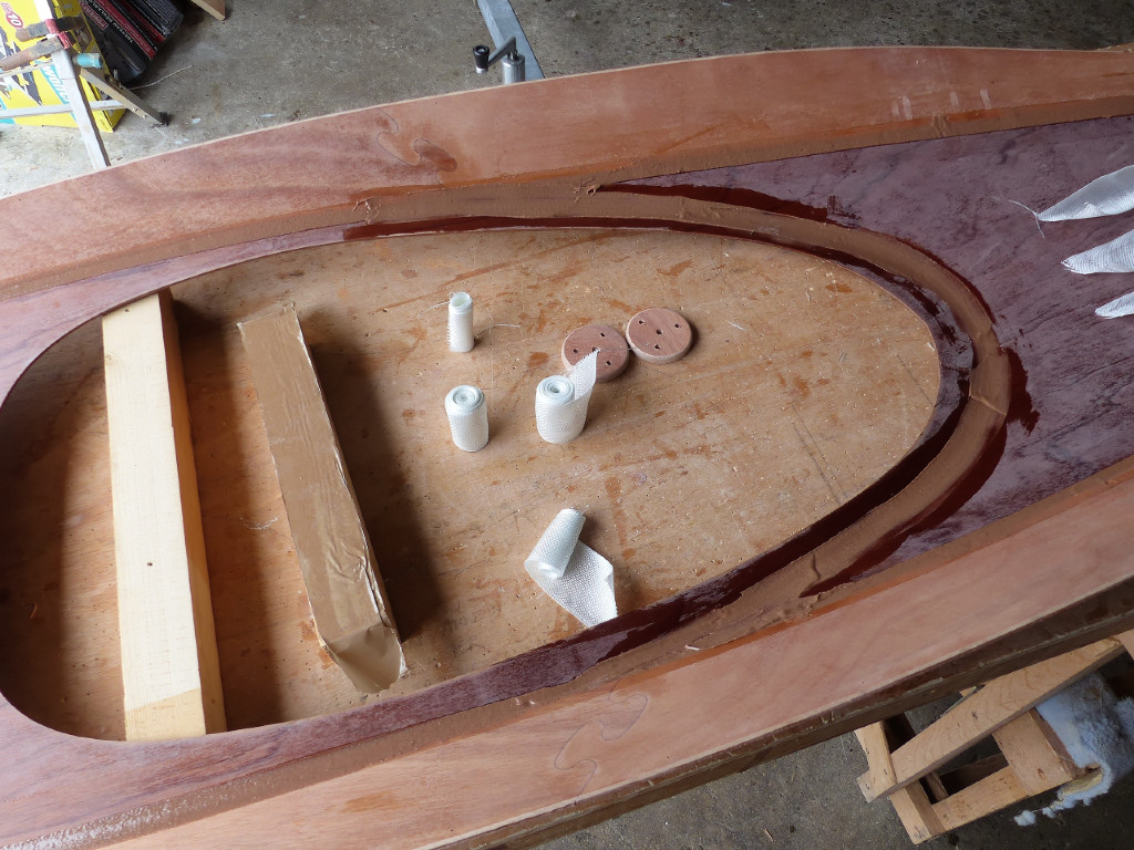 J'ai coup&eacute; les longueurs de bande de fibre de verre qui vont "armer" les joints et les ai roul&eacute;es en bobines afin de les tremper dans un verre d'&eacute;poxy claire pour les saturer avant de les d&eacute;rouler sur les joints. Les deux palets en contreplaqu&eacute; appartiennent au Skerry de Bruno, ils serviront d'embase aux filoirs de foc, et ils sont l&agrave; car je ne dois pas oublier de passer de l'&eacute;poxy claire dessus... 