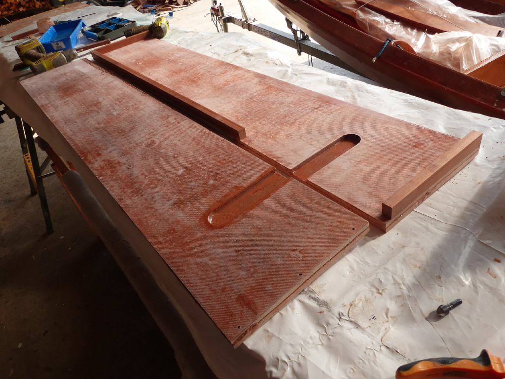 Voici les deux c&ocirc;t&eacute;s du puits de d&eacute;rive. On voit que leur face int&eacute;rieure est stratifi&eacute;e et que la structure en sapelli est d&eacute;j&agrave; coll&eacute;e sur le c&ocirc;t&eacute; tribord. Je viens de faire une retouche d'&eacute;poxy dans les deux encoches qui recevront les pivots qui seront fix&eacute;s sur la d&eacute;rive. 