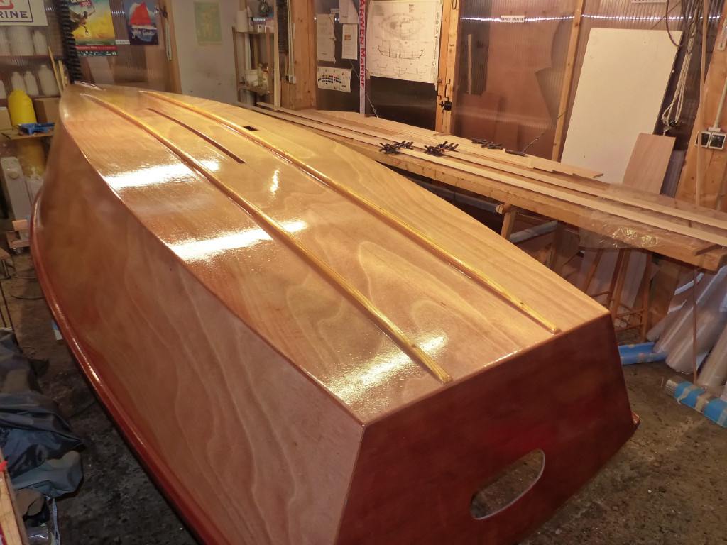 Apr&egrave;s s&eacute;chage, je passe le derni&egrave;re couche d'&eacute;poxy. Enfin, c'est la derni&egrave;re sur l'ext&eacute;rieur de la coque, et j'esp&egrave;re que ce sera effectivement la derni&egrave;re... Comme on le voit sur la table &agrave; l'arri&egrave;re-plan, j'ai commenc&eacute; &agrave; travailler sur le m&acirc;t creux en collant les scarfs des petits c&ocirc;t&eacute;s de la "boite". 